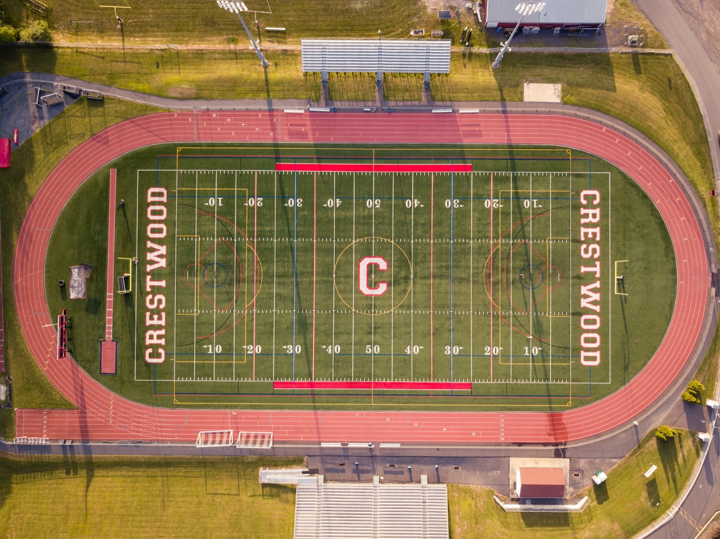 Symmetric top-down aerial view of a football field and running track