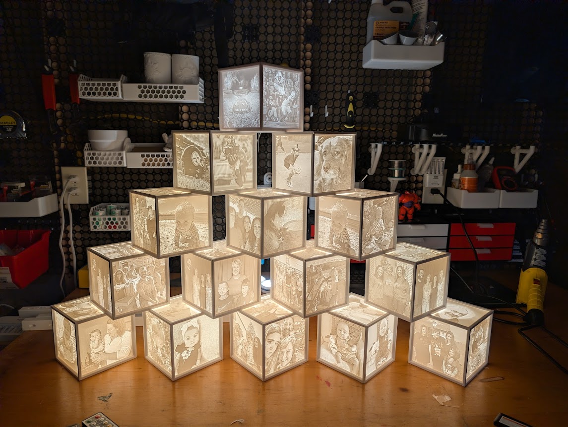 Pyramid tower of glowing lithophane photo cubes on a workbench